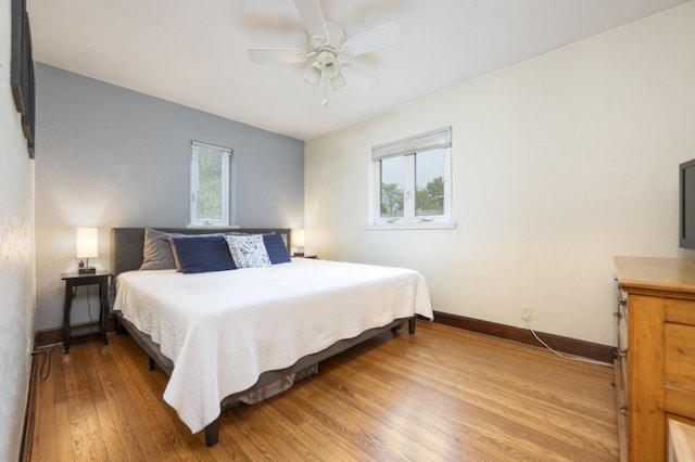 651 Eastern Ave, Bellefontaine, OH 43311 - bedroom featuring baseboards, light wood finished floors, multiple windows, and a ceiling fan