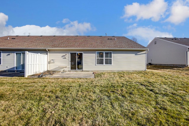 back of property featuring a patio area, a yard, and roof with shingles