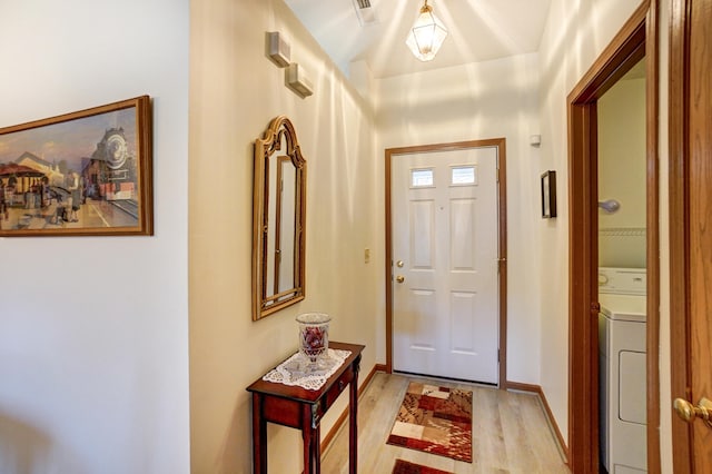 foyer entrance featuring visible vents, baseboards, washer / dryer, and light wood finished floors