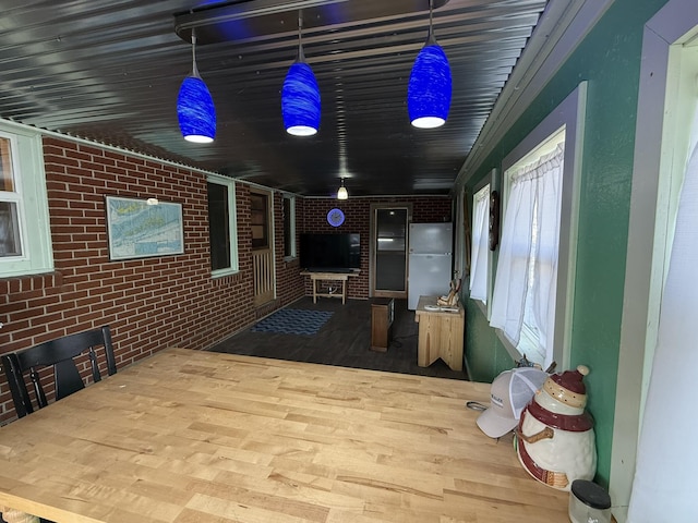 interior space with hardwood / wood-style floors and brick wall