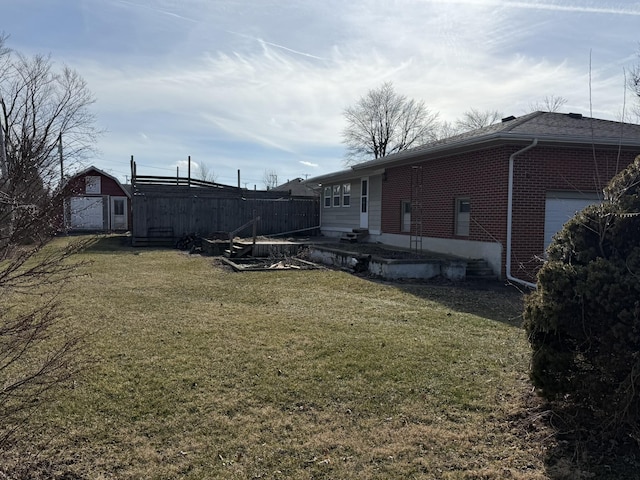 view of yard featuring a garage and a storage unit