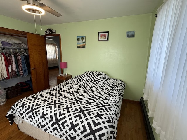 bedroom featuring dark hardwood / wood-style flooring, a closet, and ceiling fan