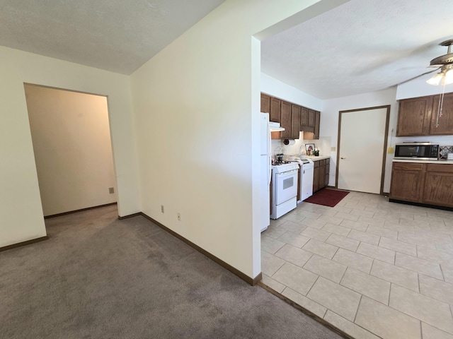 3032 Armsgate Rd Unit 25, Springfield, OH 45503 - kitchen featuring stainless steel microwave, ceiling fan, light countertops, and white range with gas stovetop