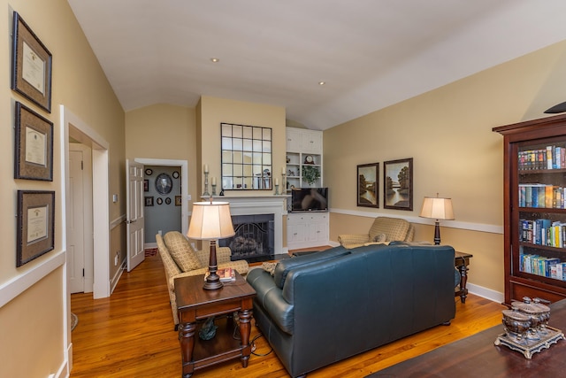 living room featuring vaulted ceiling and hardwood / wood-style floors