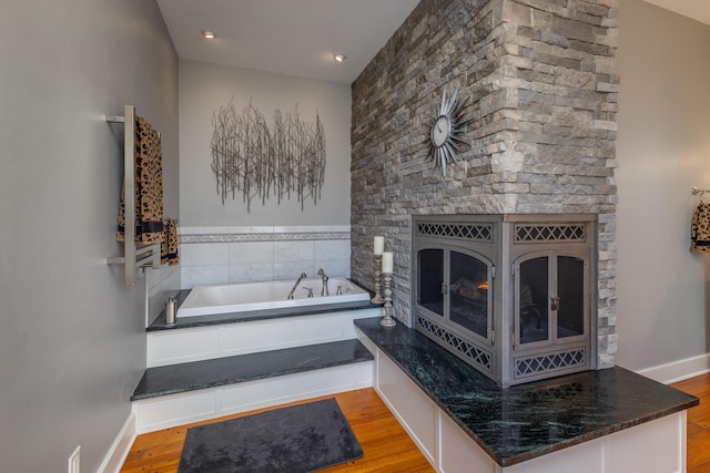 bathroom with hardwood / wood-style flooring and a tub