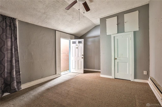 interior space with a textured ceiling, baseboard heating, carpet floors, and vaulted ceiling