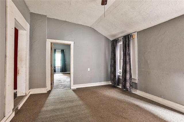unfurnished room featuring a ceiling fan, a textured ceiling, lofted ceiling, and carpet floors