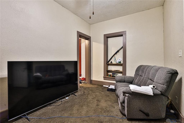 living area featuring a textured ceiling, carpet flooring, and baseboards