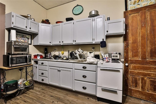 kitchen featuring stainless steel microwave, a toaster, dark wood-type flooring, and white range with electric cooktop