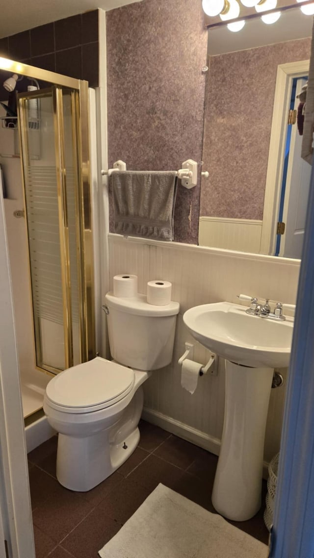 bathroom featuring tile patterned flooring, an enclosed shower, and toilet