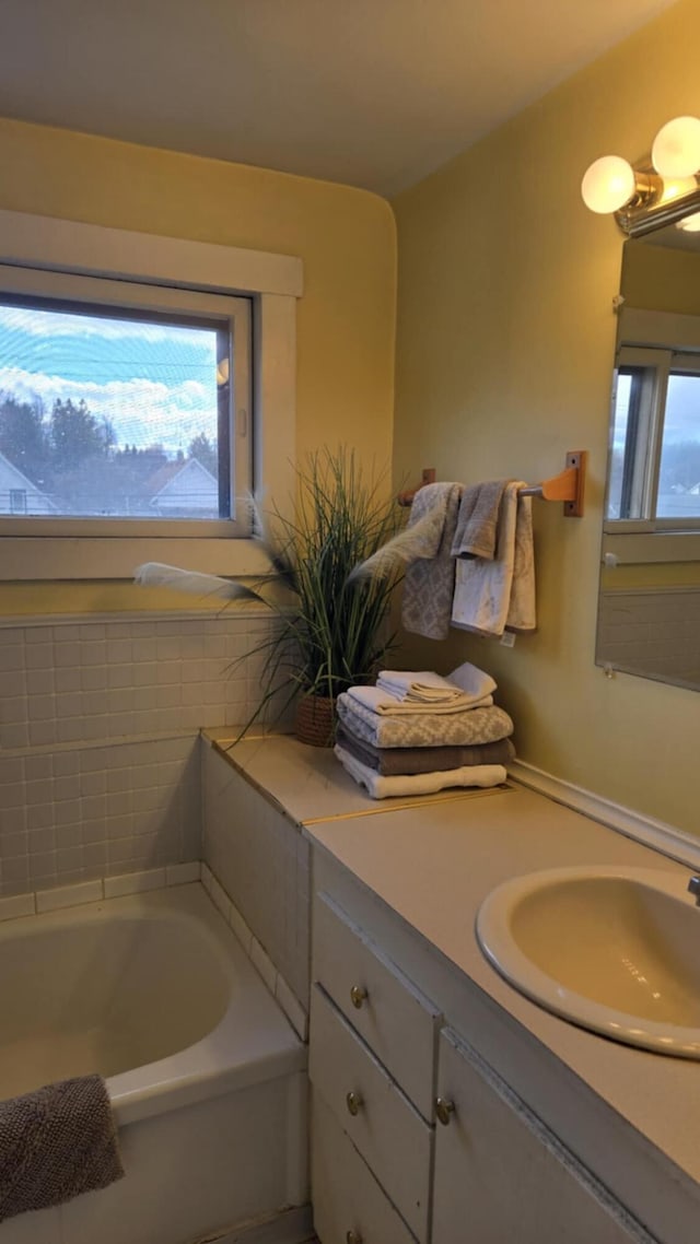 bathroom with vanity and a bath