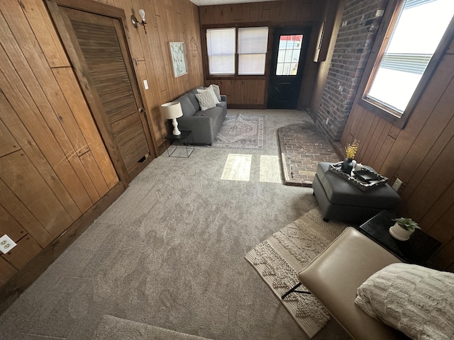 living room with wood walls and light colored carpet