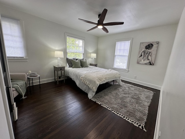 bedroom featuring multiple windows, ceiling fan, and dark hardwood / wood-style flooring