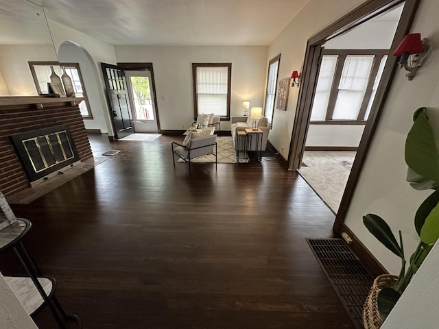 living room featuring a fireplace and dark wood-type flooring