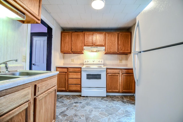 220 Williams St, Troy, OH 45373 - kitchen with white appliances, under cabinet range hood, light countertops, brown cabinetry, and light stone finish floors