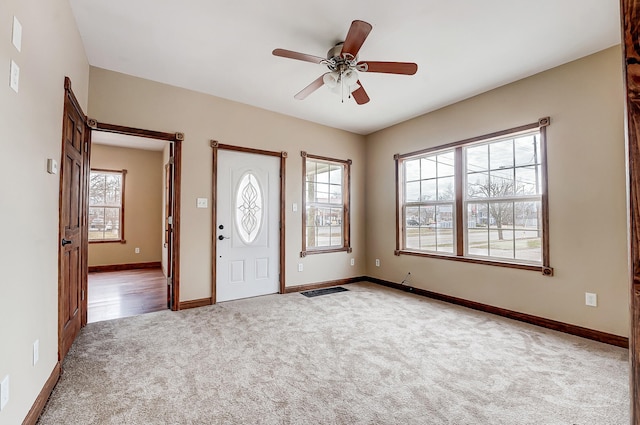 carpeted entryway with baseboards and ceiling fan