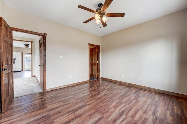 empty room featuring baseboards, ceiling fan, and wood finished floors