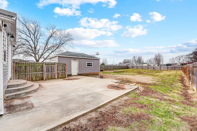 view of yard with an outdoor structure, a fenced backyard, and a patio area