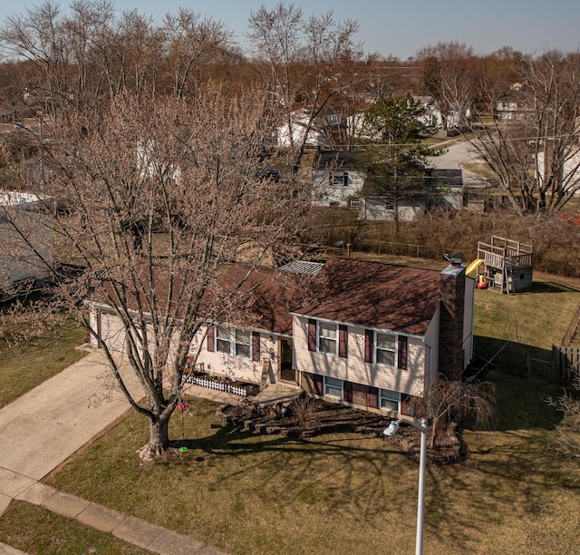 view of front of house featuring a garage, a chimney, concrete driveway, and a front yard