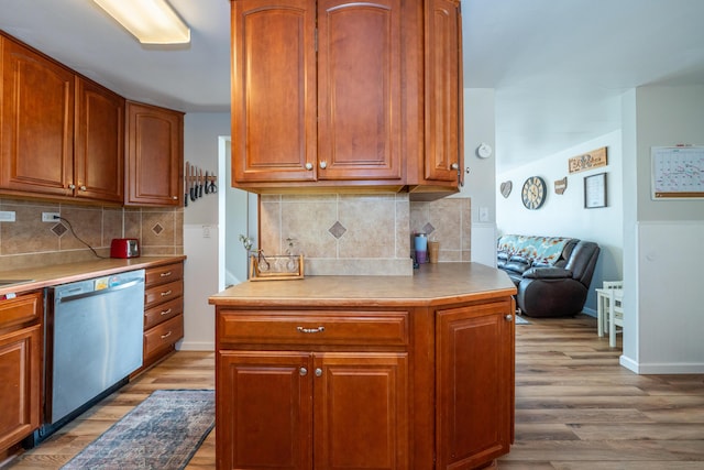 kitchen with light wood-style floors, stainless steel dishwasher, and light countertops