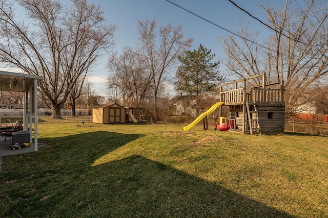 view of yard with an outbuilding, a shed, a playground, and fence