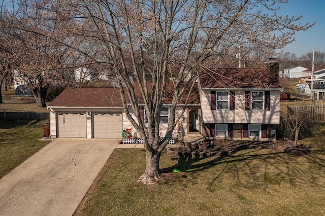 tri-level home featuring a garage, brick siding, concrete driveway, and a front lawn