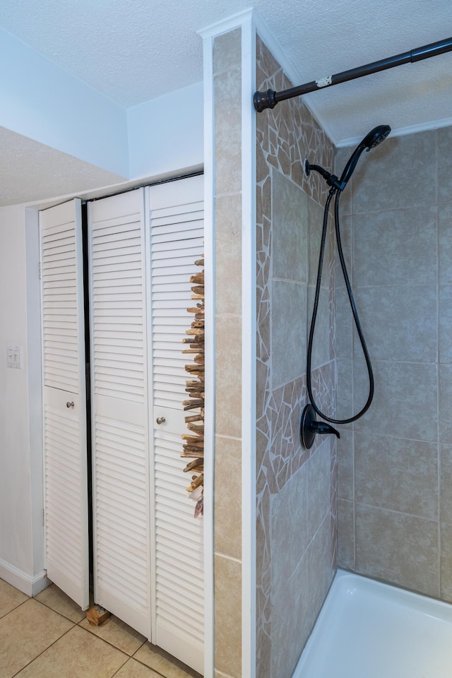 full bath with a textured ceiling, tile patterned floors, and tiled shower