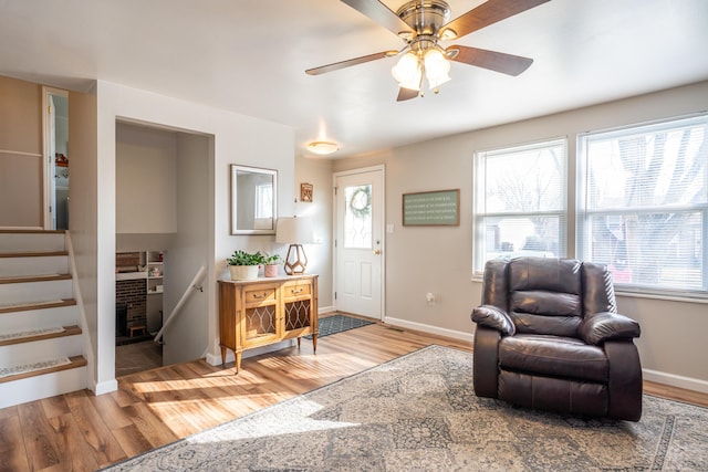 entryway with stairs, light wood-style floors, and baseboards