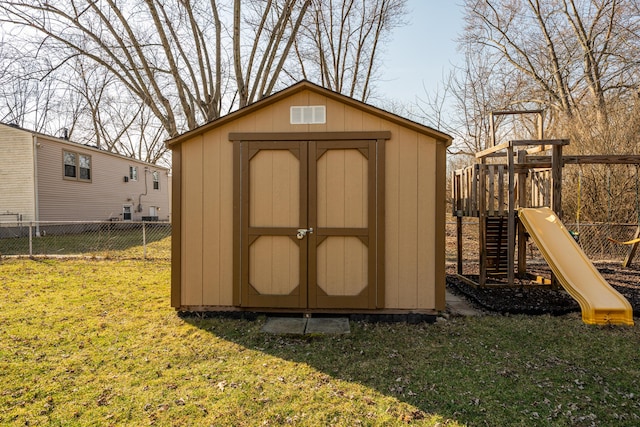 view of shed featuring a playground and fence