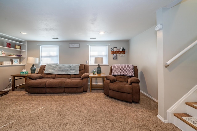 carpeted living area with visible vents, baseboards, and stairs