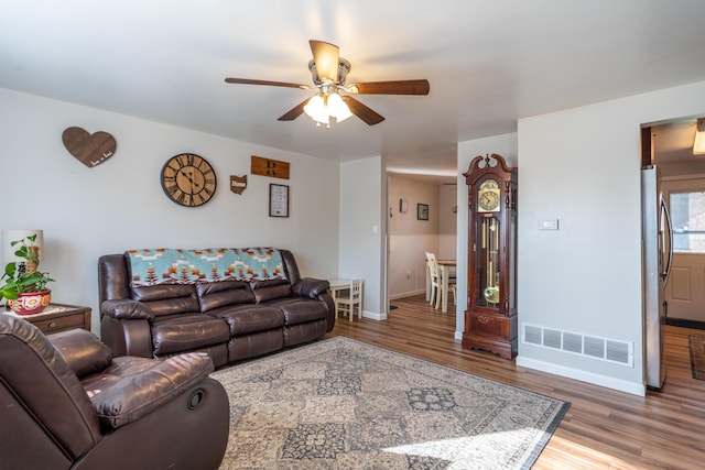 living room with visible vents, baseboards, a ceiling fan, and wood finished floors