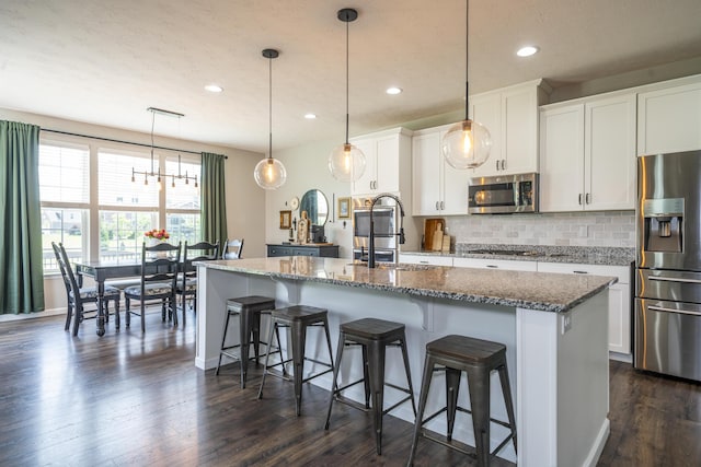 8754 Elysee Cir, Washington Twp, OH 45458 - kitchen featuring appliances with stainless steel finishes, a center island with sink, tasteful backsplash, white cabinets, and recessed lighting