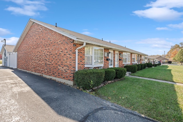 exterior space featuring brick siding and a yard