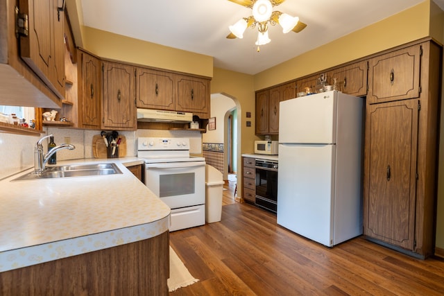 704 Campbell Rd, Sidney, OH 45365 - kitchen featuring a sink, white appliances, under cabinet range hood, arched walkways, and a ceiling fan