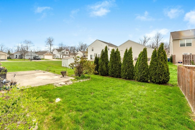 view of yard with fence, a residential view, and a patio