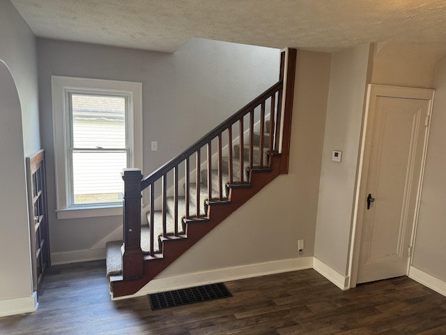 stairs featuring hardwood / wood-style flooring and a textured ceiling