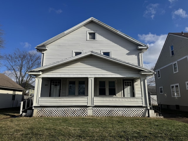 back of property featuring covered porch and a lawn