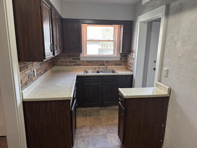 kitchen with tasteful backsplash, sink, and dark brown cabinets