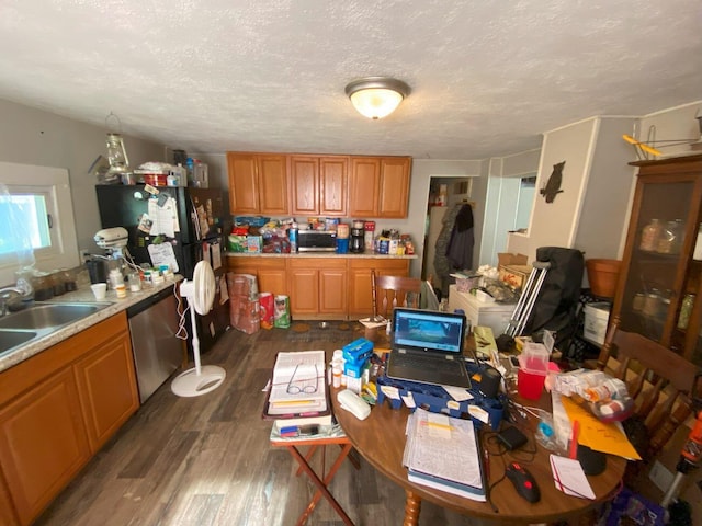 611 W Baird St, West Liberty, OH 43357 - kitchen featuring stainless steel dishwasher, dark wood-style flooring, light countertops, a textured ceiling, and brown cabinetry