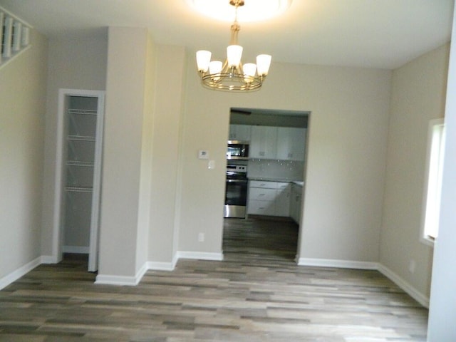16 E Walnut St, Jeffersonville, OH 43128 - unfurnished dining area with a chandelier, wood finished floors, and baseboards