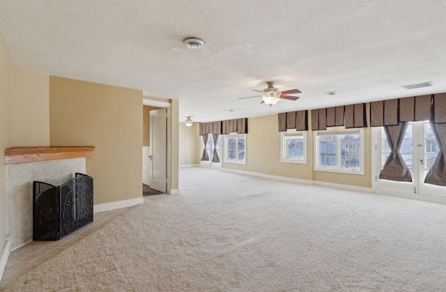 unfurnished living room featuring light carpet, a fireplace, and a textured ceiling