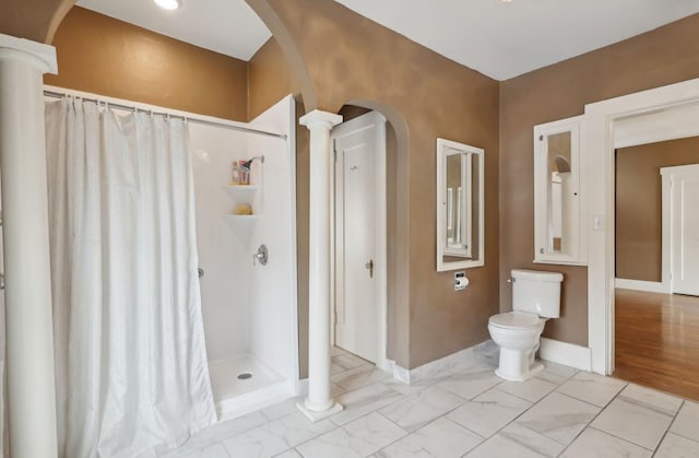 bathroom with baseboards, marble finish floor, a stall shower, and ornate columns