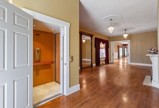 foyer featuring baseboards and wood finished floors