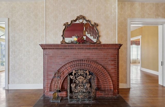 details featuring a brick fireplace, wood finished floors, and baseboards