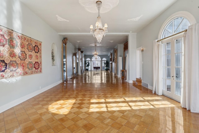 foyer featuring baseboards, french doors, and an inviting chandelier