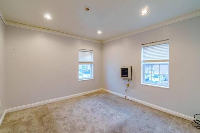 empty room featuring carpet floors, heating unit, baseboards, and ornamental molding