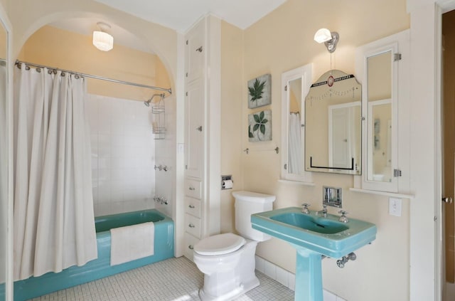 bathroom featuring tile patterned flooring, toilet, and shower / bathtub combination with curtain