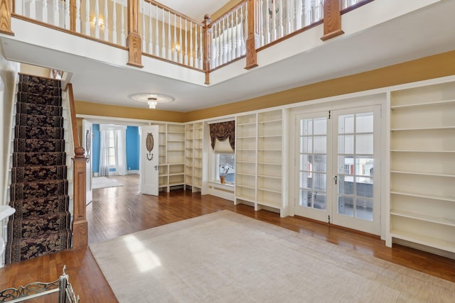 interior space featuring stairs, a high ceiling, and wood finished floors