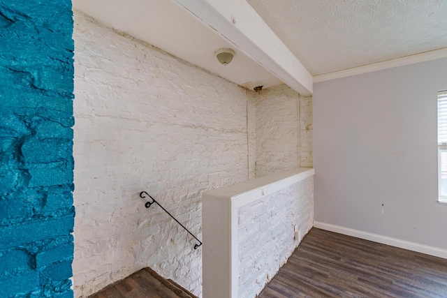 interior space featuring a textured ceiling, baseboards, dark wood-style floors, beamed ceiling, and crown molding