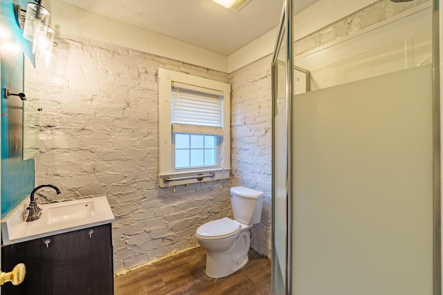 full bathroom featuring a textured ceiling, vanity, toilet, and wood finished floors